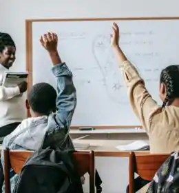 Black woman with pupils in classroom