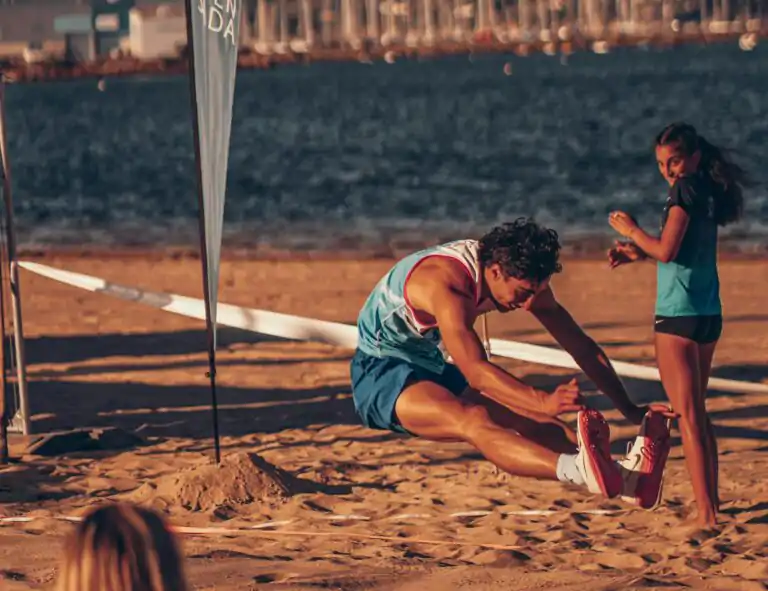 Man in Sportswear Doing Long Jump on Sand